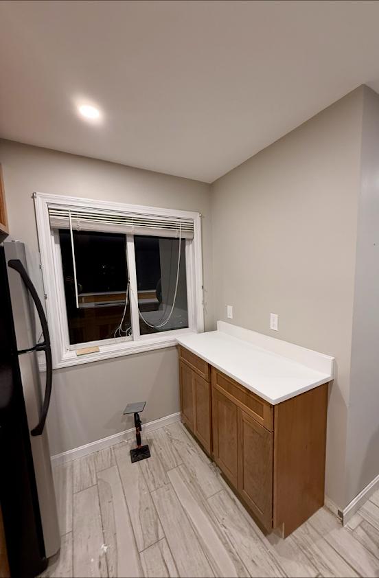 Finished kitchen corner with new cabinets, countertop, and tile floor
